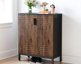 May include: A wooden cabinet with a geometric design on the doors. The cabinet has a dark brown wood grain finish with a black frame and legs. A vase of white flowers and decorative items sit on top. Black shoes are visible under the cabinet.