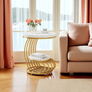 May include: A modern side table with a white marble top and a gold metal frame. The table has a curved design with a second tier for storage. A vase of flowers and a teacup are on the top.