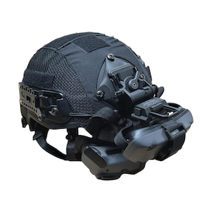 May include: Black tactical helmet with attached night vision goggles. The helmet features a mesh fabric covering the top and sides, with multiple mounting points and adjustable straps. The goggles are positioned in front of the eyes.