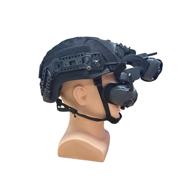 May include: Black tactical helmet with attached night vision goggles and communication headset. The helmet features multiple rails and a mesh top. The headset includes ear cups and a microphone. The helmet is mounted on a mannequin head.