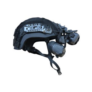 May include: Black tactical helmet with attached night vision goggles and communication headset. The helmet features a rail system for accessories and adjustable straps for a secure fit. The headset includes ear protection and a microphone.