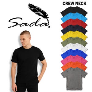 May include: A black crew neck t-shirt with the word "Sada" and a feather graphic. A variety of colored crew neck t-shirts are displayed, including black, blue, red, navy, yellow, olive, white, pink, orange, and gray.