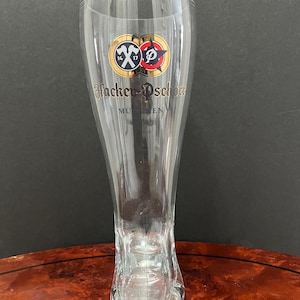 May include: A clear glass beer boot with a gold logo that says "Hacker-Pschorr München".