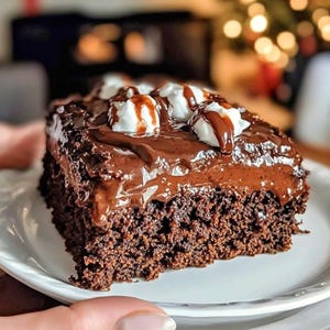 May include: A slice of rich chocolate cake on a white plate. The cake is covered in chocolate frosting and topped with dollops of whipped cream and chocolate drizzle. The cake appears moist and delicious, perfect for dessert.