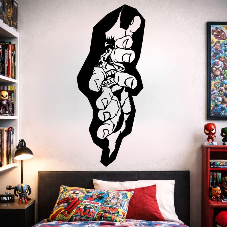 May include: A black and white wall decal depicting a stylized hand reaching out. The design includes a detailed illustration of a face with sharp teeth. The decal is applied to a white wall above a bed with colourful pillows.