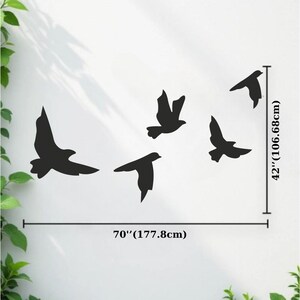 May include: Black silhouette of five birds in flight, arranged on a white wall. The artwork spans 70 inches (177.8cm) wide and 42 inches (106.68cm) high. The birds are depicted with outstretched wings, creating a sense of movement and freedom.