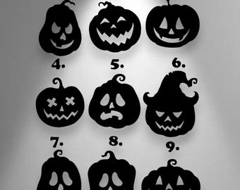 Puede incluir: Una colección de nueve siluetas de calabazas negras dispuestas en una cuadrícula de tres por tres, cada una numerada del uno al nueve. Las calabazas presentan diversas expresiones faciales talladas, incluyendo sonrisas dentadas y ojos en forma de cruz.