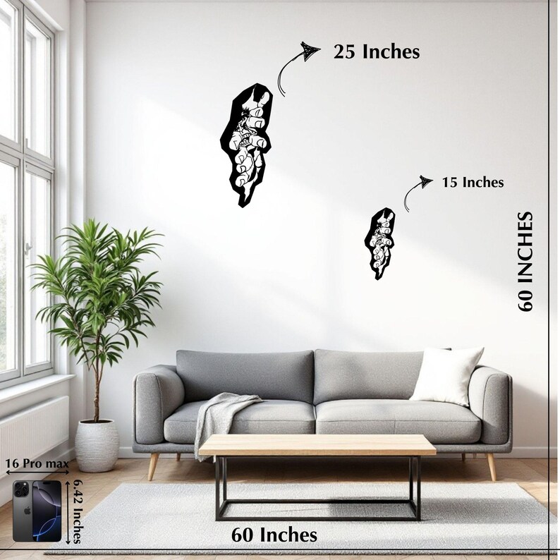 May include: Two black wall art pieces, one 63.5 cm and the other 38.1 cm, are displayed on a white wall. The art is above a grey sofa with a wooden coffee table. A tall potted plant is to the left.
