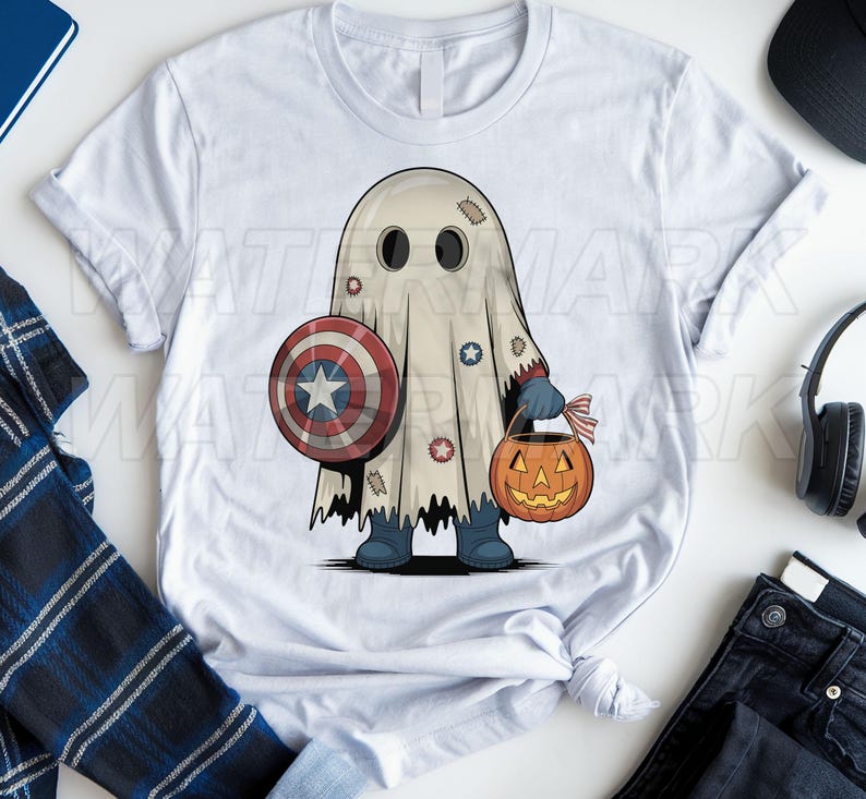 May include: A white t-shirt featuring a graphic of a ghost wearing a sheet with patches, holding a red, white, and blue circular shield and an orange jack-o'-lantern candy bucket. The ghost wears dark blue boots and gloves.
