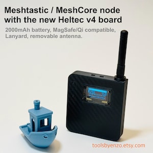 May include: A black Meshtastic / MeshCore node with a removable antenna and a small blue boat model. The device has a screen displaying data and includes the text "Meshtastic / MeshCore node with the new Heltec v4 board". It also has a 2000mAh battery.