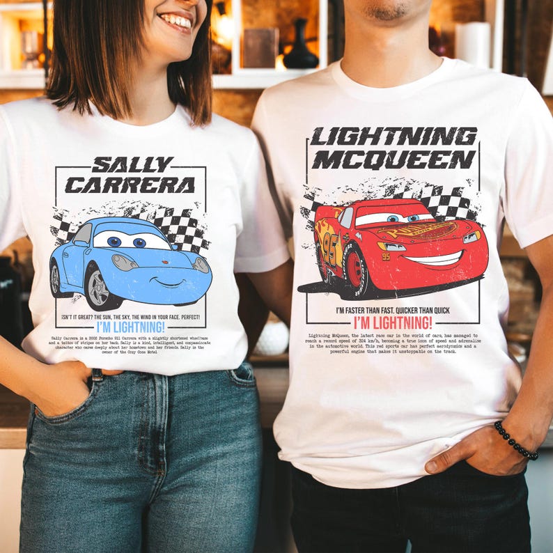 May include: White t-shirts featuring cartoon cars. One shirt displays a blue car with "SALLY CARRERA" and "I'M LIGHTNING!" text. The other shirt shows a red car with "LIGHTNING MCQUEEN" and "I'M LIGHTNING!" text.