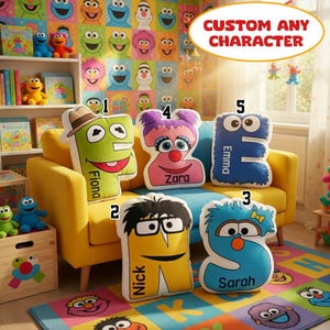 May include: A collection of colorful character-shaped pillows, each with a name, displayed on a yellow sofa. The pillows are in the shape of letters and cartoon characters. The background features a Sesame Street-themed wallpaper.