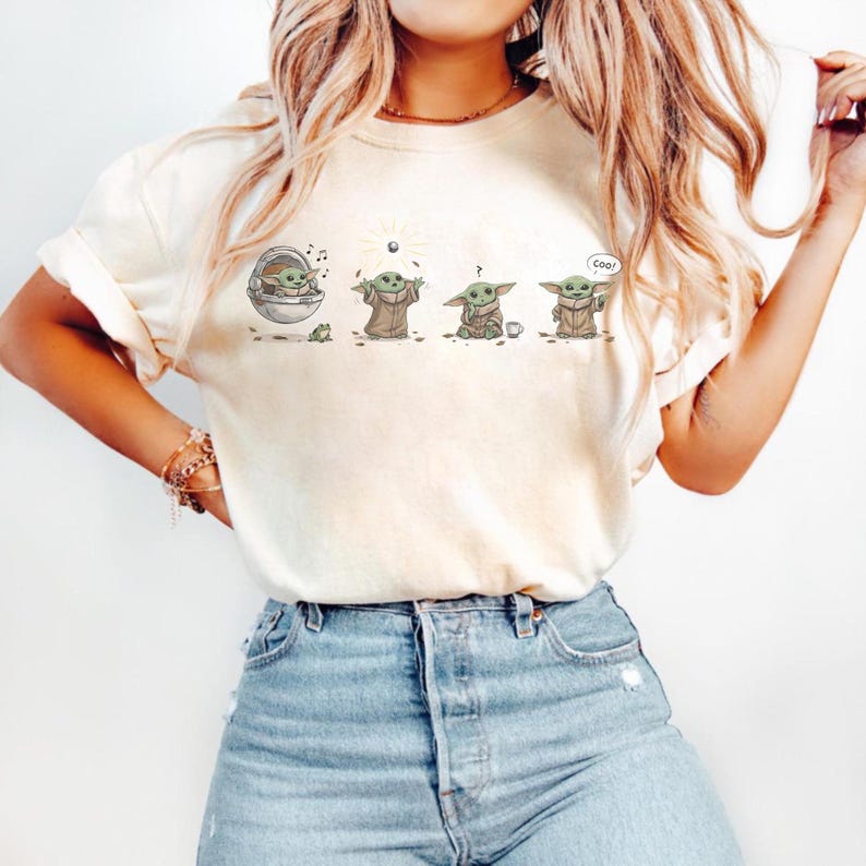 May include: Cream-colored t-shirt featuring a cartoon sequence of a character from a popular science fiction series. The character is depicted in various poses, with the word "Cool" in a speech bubble.