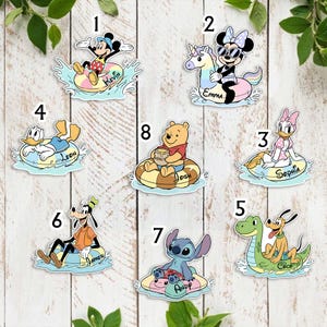 May include: A collection of colorful cartoon character stickers, including Mickey Mouse, Minnie Mouse, Donald Duck, Daisy Duck, Goofy, Pluto, Winnie the Pooh, and Stitch, each riding an inflatable float. Names are printed on the floats.