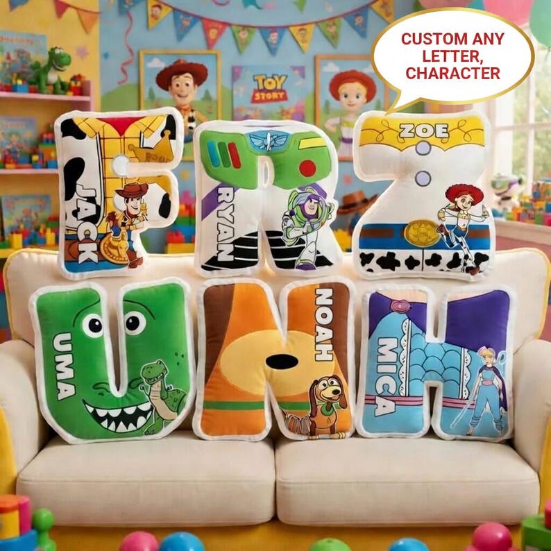 Peut inclure: Coussins personnalis&eacute;s en forme de lettres avec des personnages de Toy Story. Chaque coussin affiche une lettre et un personnage, avec des noms comme Jack, Ryan, Zoe, Uma, Noah et Mica. Les coussins sont sur un canap&eacute; blanc.