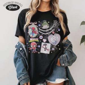 May include: Black Comfort Colors t-shirt featuring a colorful graphic of Spider-Man and friends. The design includes various characters, hearts, and the text "Spidey and His Amazing Friends". The shirt has a crew neck and short sleeves.