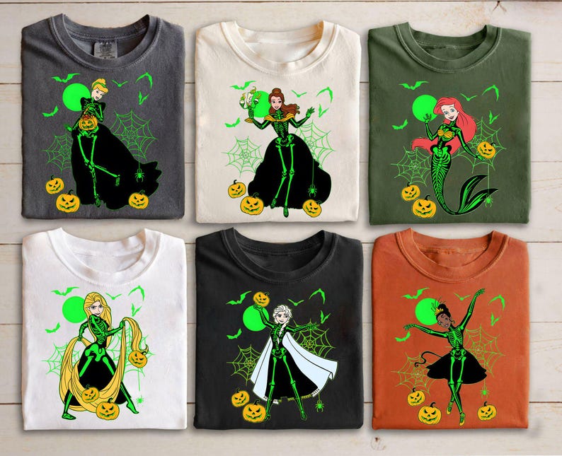 May include: Six t-shirts with Halloween-themed designs. Each shirt features a princess character with a skeleton design, spiderwebs, bats, and jack-o'-lanterns. The shirts are in various colors, including gray, white, green, black, and orange.