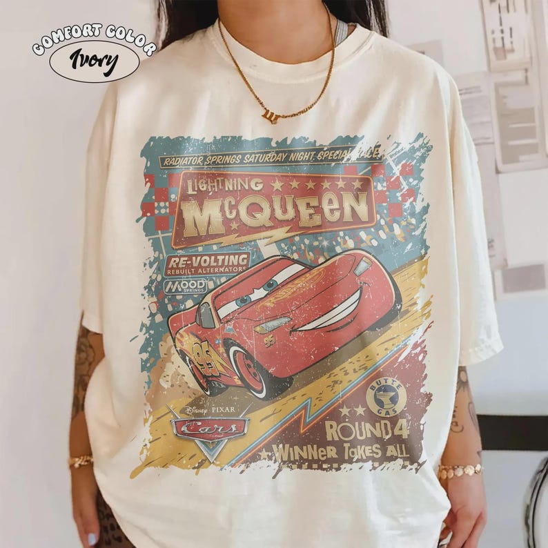 May include: Ivory Comfort Color t-shirt featuring a distressed graphic of Lightning McQueen from the Disney Pixar Cars movie. The design includes text that reads "Radiator Springs Saturday Night Special Race" and "Round 4 Winner Takes All."
