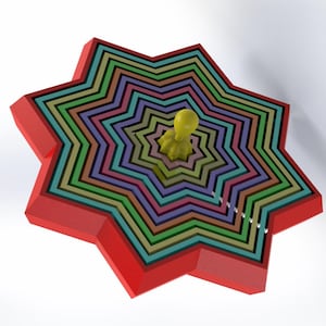 Puede incluir: Un cortador de galletas con forma de estrella de colores con una figura amarilla en el centro. El cortador está hecho de metal y tiene un borde exterior rojo.