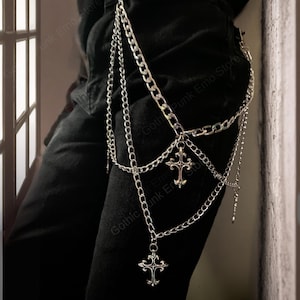 May include: Silver-toned chain accessory with multiple strands and dangling cross pendants. The chains are attached to a belt loop, creating a layered effect. The accessory is designed to be worn on the leg, adding a gothic or punk aesthetic.