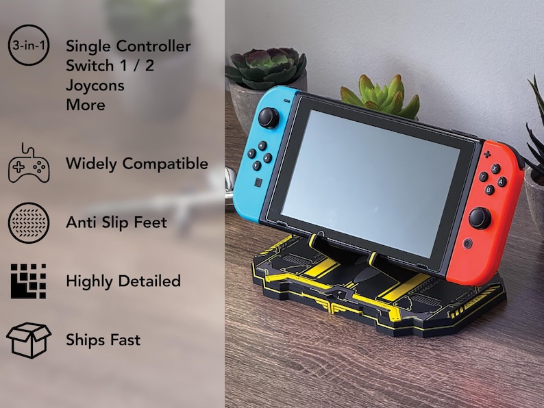 以下が含まれることがあります： 黒と黄色のSwitchコンソールスタンド。Switchコンソールが配置されています。スタンドは幾何学的なデザインで、「3-in-1」、「Single Controller」、「Widely Compatible」、「Anti Slip Feet」の文字があります。Switchコンソールには青と赤のコントローラーが付いています。