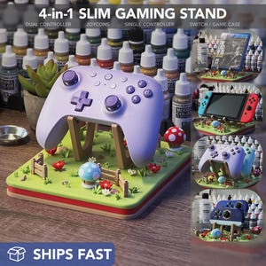 May include: A 4-in-1 slim gaming stand in the image. The stand is designed to hold a dual controller, Joycons, a single controller, and a Switch game case. The stand is light purple and has a decorative base with a green lawn, mushrooms, and a fence. The text "SHIPS FAST" is visible.