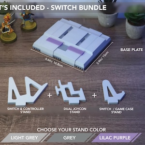May include: A light grey Switch bundle with a base plate measuring 6.6 inches by 5.9 inches, plus stands for the controller, Joycons, and game case. The text says "Choose Your Stand Color" with options in light grey, grey, and lilac purple.