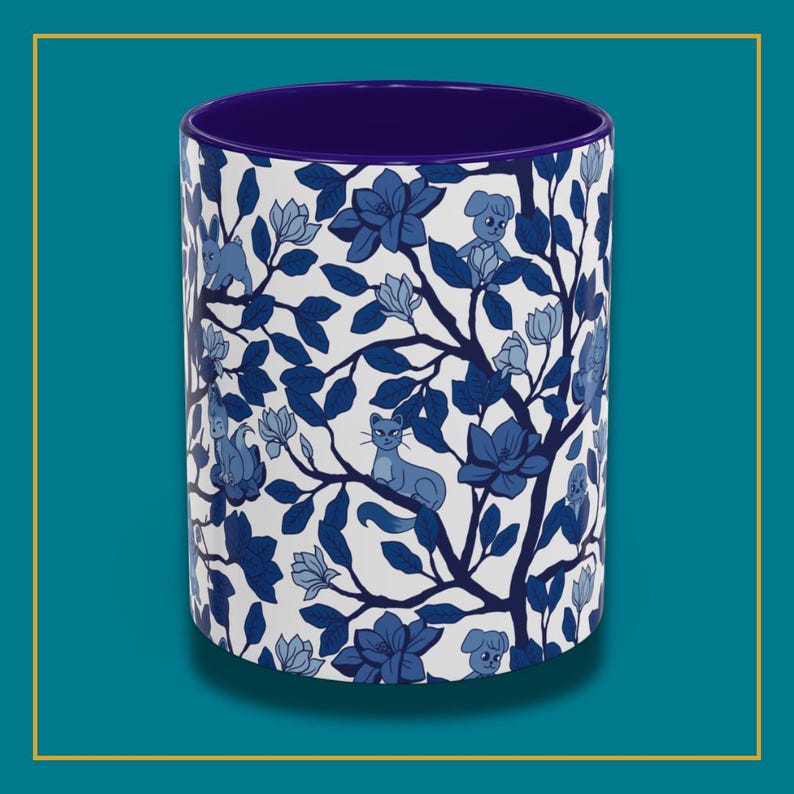 Pu&ograve; includere: Tazza cilindrica in ceramica con un design floreale e animale blu e bianco. L'esterno presenta un motivo di fiori blu, foglie, gatti e cani su sfondo bianco. L'interno della tazza &egrave; di colore blu scuro.
