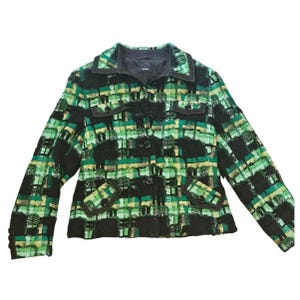 May include: A green, black, and yellow plaid jacket with a button-up front, two chest pockets, and two lower pockets. The jacket has a dark brown trim around the collar, pockets, and cuffs. The jacket is a medium length.