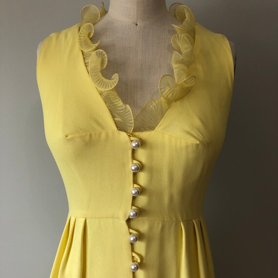 yellow dress with gold buttons A corseted yellow gown with cape