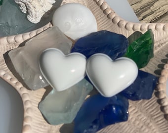 Pendientes modernos minimalistas blancos en forma de corazón para un look limpio y elegante.