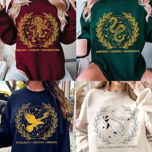 Può includere: Quattro felpe a maniche lunghe in bordeaux, verde, blu navy e crema. Ognuna presenta un emblema dorato con un animale diverso e parole associate: leone, serpente, aquila e tasso. Le felpe sono in stile casual e confortevole.
