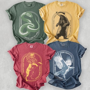 May include: Four short-sleeved t-shirts in various colors: green, yellow, red, and blue. Each shirt features a different animal graphic inside an oval frame, with text around the frame. The graphics include a snake, badger, lion, and eagle.