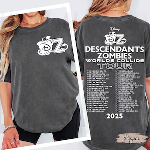 Peut inclure: T-shirt gris foncé avec le logo Disney et les lettres "DZ", annonçant la tournée "Descendants Zombies Worlds Collide Tour" avec les dates de 2025. Un style de chemise décontracté et confortable.