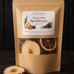 May include: A brown kraft paper pouch containing dried botanicals for a simmer pot. The label reads Herb & Hearth Creations Autumn Apothecary, listing dried apples, orange, cinnamon, cloves, star anise, juniper berries, rosemary, and bay leaf.