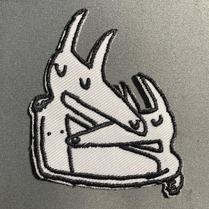 Puede incluir: Parche bordado en blanco y negro de dos animales de dibujos animados abrazándose.