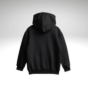 May include: A black hoodie, viewed from the back, featuring a hood and long sleeves. The image highlights the garment's shape and design. The material appears to be soft and comfortable, suitable for casual wear.
