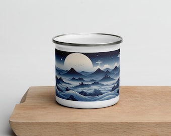 May include: A white enamel mug with a blue and white illustration of a mountain range under a full moon. The illustration is reminiscent of a Japanese landscape painting.