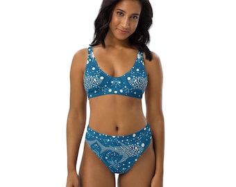 May include: A teal blue bikini with a white polka dot pattern. The bikini top has a scoop neck and the bikini bottom has a high waist.