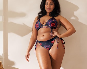 May include: A black and red patterned bikini with a halter top and a high-cut bottom. The bikini has a geometric design with circles and stars.