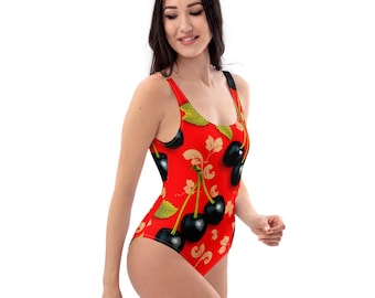 May include: A red one-piece swimsuit with a cherry print. The cherries are black with green stems and leaves.