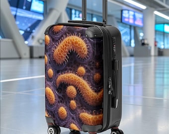 May include: Black rolling suitcase with a vibrant, detailed pattern of orange and yellow organic shapes against a dark purple background. The suitcase has a retractable handle and four wheels. The brand name "Ripplez" is visible in the lower left corner.