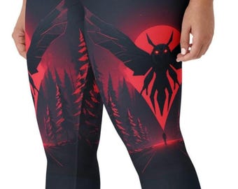 May include: Black leggings with a red and black graphic design. The design features a red sun, a silhouette of a moth-like creature, and a forest scene. The leggings are made of a stretchy material.