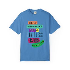 May include: A light blue t-shirt with the text "PROUD PARENT OF A LIMITLESS KID" in colorful block letters. The name "MICHAEL LEE" is printed in green script below the text.