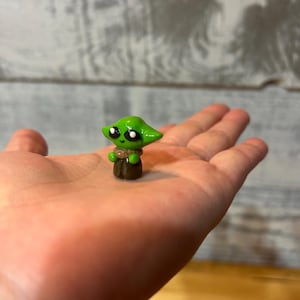 Figura de Grogu kawaii en miniatura de arcilla polimérica hecha a mano. Inspirada en Star Wars y El Mandaloriano.