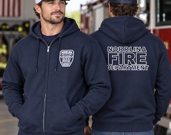 以下が含まれることがあります： 左胸に白いNorrlina Volunteer Fire Deptの盾ロゴ、背面に大きな白い文字でNorrlina Fire Departmentとプリントされたネイビーのジップアップパーカー。ネイビーとホワイトのベースボールキャップを着用。