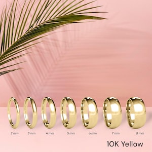 Puede incluir: Un conjunto de ocho alianzas de oro en diferentes anchos, que van de 2 mm a 8 mm. Las alianzas se muestran sobre un fondo rosa. 10K Yellow.