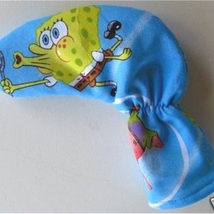 May include: A blue golf club head cover featuring a cartoon image of SpongeBob SquarePants blowing bubbles. The cover also includes an image of Patrick Star. The cover is made of a soft fabric.