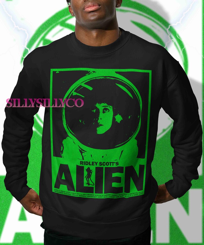 Pu&ograve; includere: Felpa nera con grafica verde di Alien di Ridley Scott. La grafica include un ritratto di una donna con un casco spaziale e il titolo del film. La felpa ha il testo "SillySillyCo" sul lato sinistro.