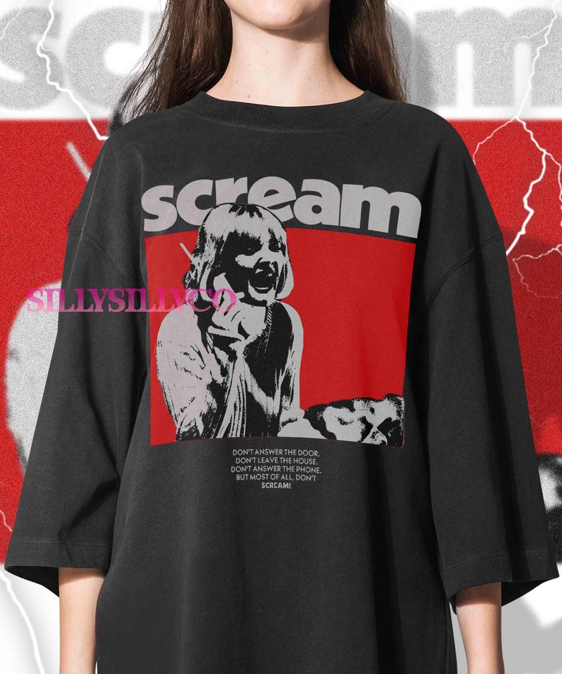 May include: Black graphic t-shirt with the word "scream" in gray letters above a red rectangle. The graphic features a distressed image of a person screaming into a phone. Text below reads "Don't answer the door..." and "Scream!"